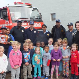 Links agter ontvang Johanay Michau (4) van  Cool Kids Kleuterskool haar Brandweerprys van Cynthia Desemela